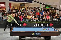 Woman shoots a pool break in mid-air