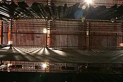 Channel-type grid, viewed from below with drapes, battens, and electrics visible.