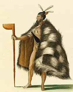An indigenous Māori man from New Zealand, wearing a cloak and holding a club.