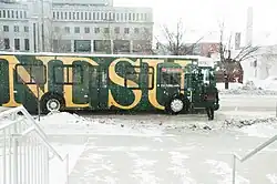 A MATBUS vehicle waits in the snow while a rider boards the bus.