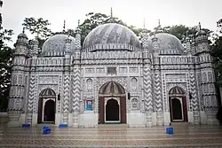 The eastern façade has three doorways, each opening under a half-domed vault and flanked by slender minarets