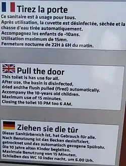 Public restroom sign with broken English and German directly translated from French.